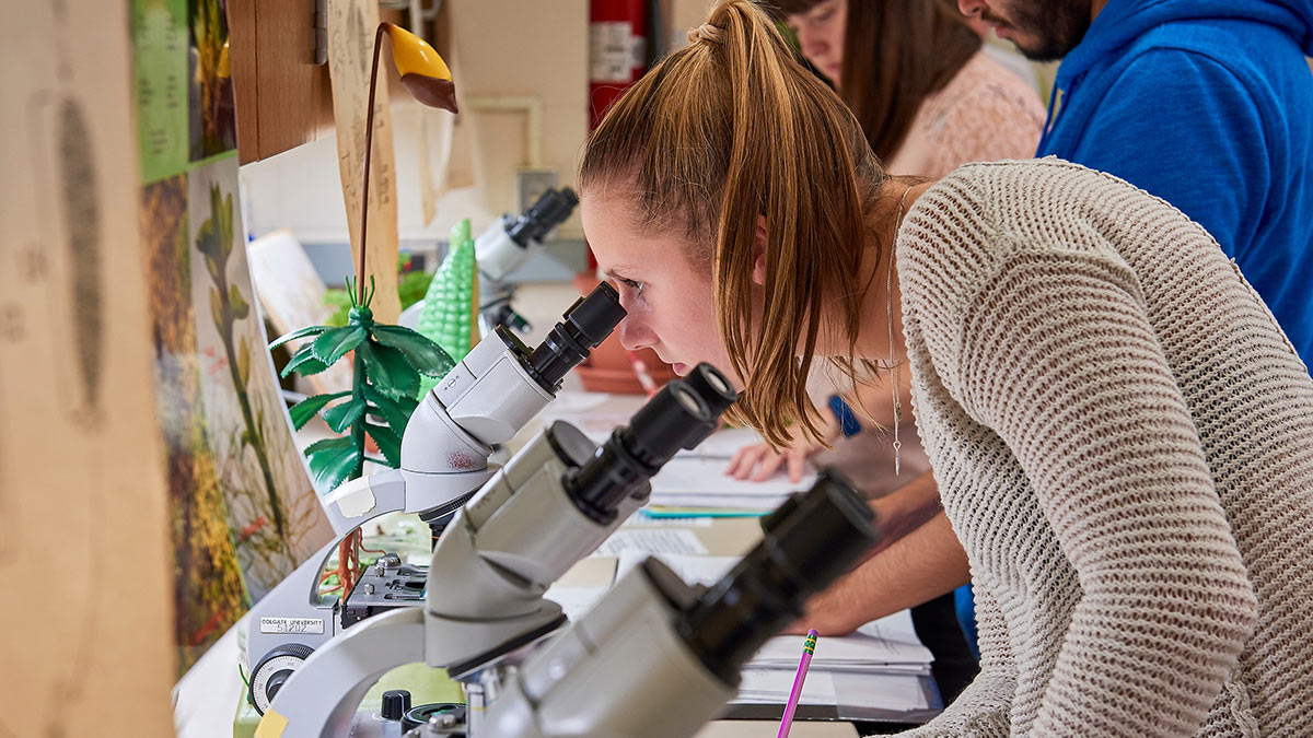 Student looking through microscope