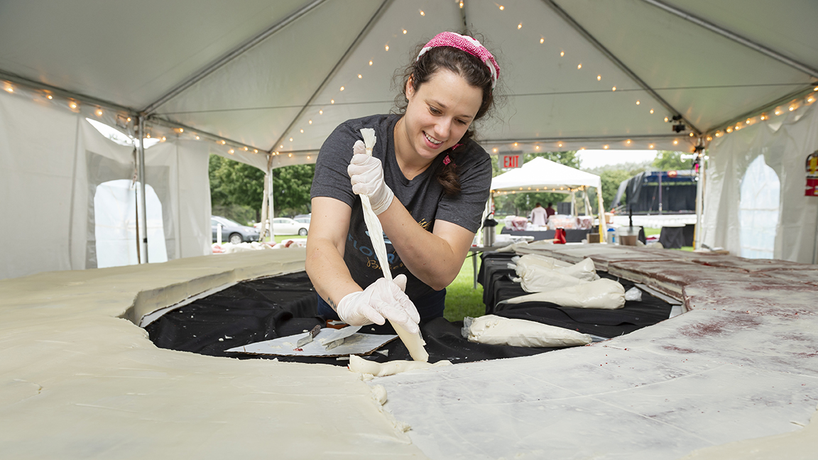 Britty O'Connor ’12, MA’13 decorates the Bicentennial cake