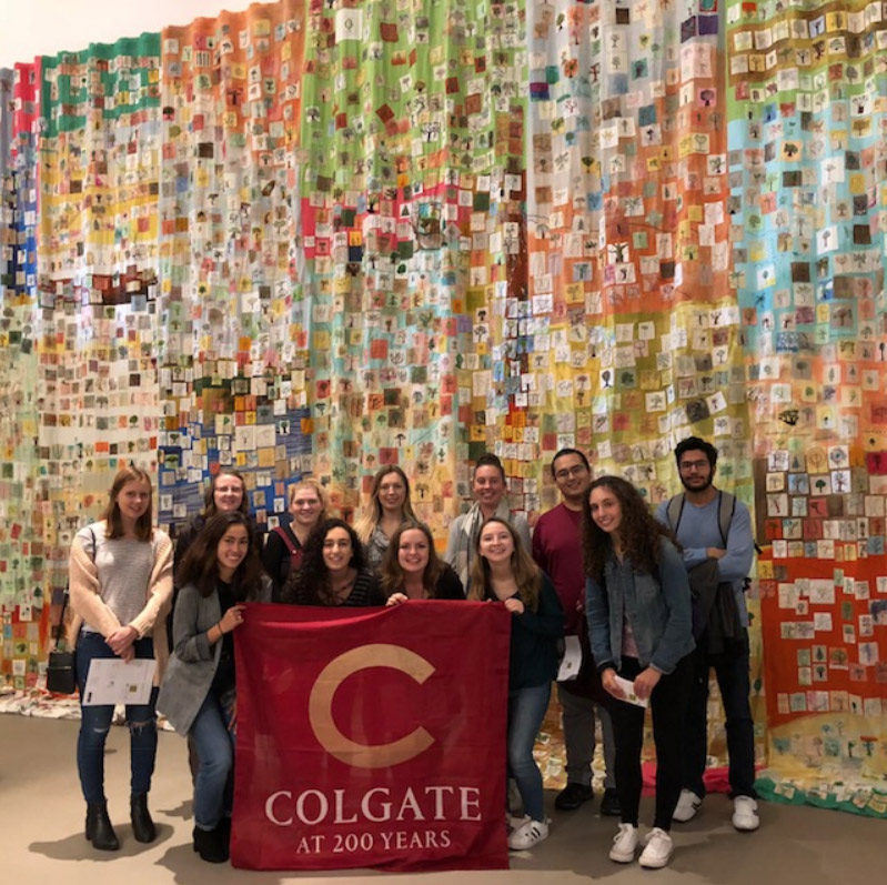 Students with Banner in front of large quilt