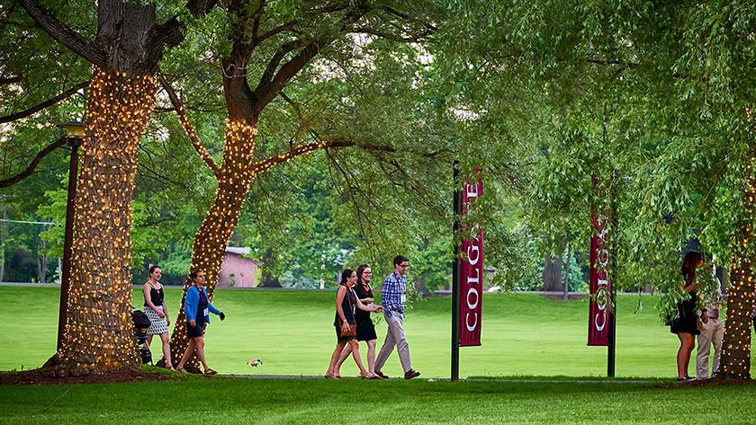 Alumni walk down Willow Path, illuminated by lights at Reunion