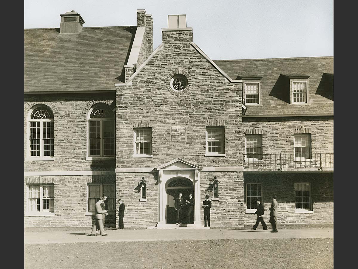 Students mill about the entryway to James C. Colgate Hall in an archival image